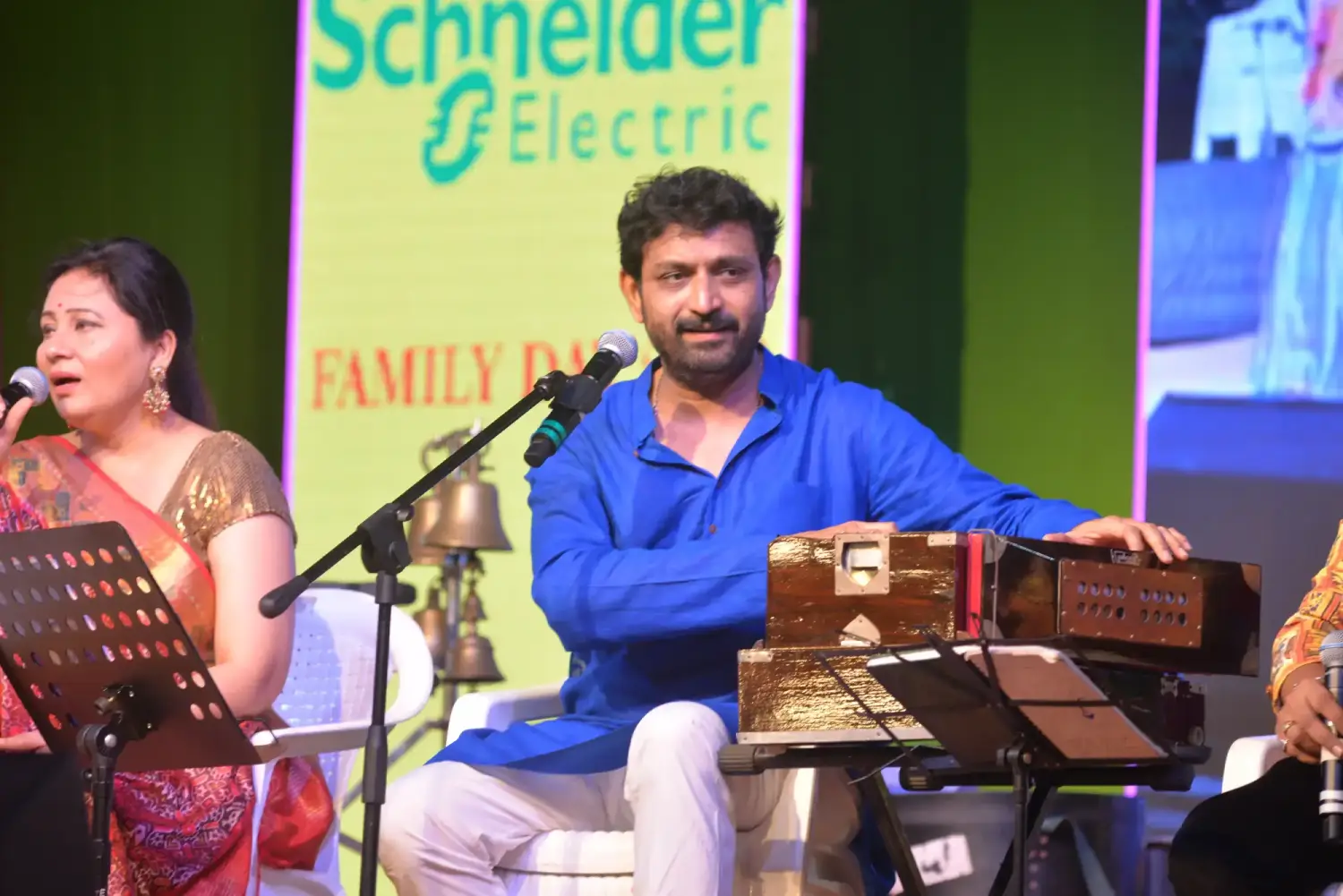 Men lighting ceremonial lamp at event with ITT banner in background